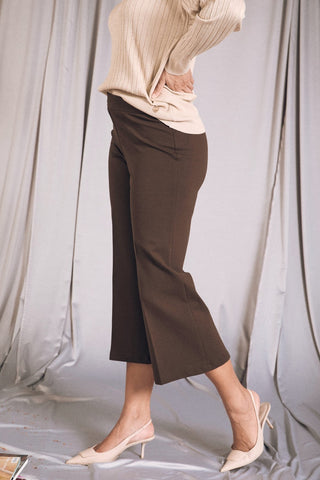 Pantalone comfy cropped mori con vita elastica, abbinato a maxi pull e tacchi eleganti, look alla moda.