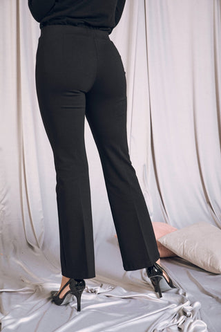 Pantalone flare neri con vita elastica, indossati con tacchi, perfetti per ogni occasione da business a glam.